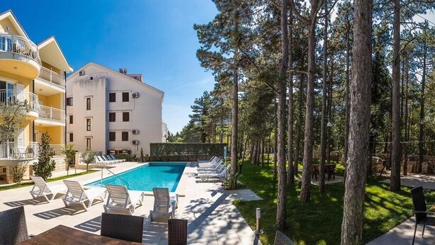 Un hôtel doté d’une piscine, d’un espace extérieur aménagé et d’une zone boisée.