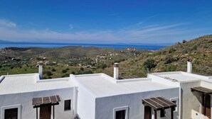 A white-roofed building with a view of a coastal landscape. - Kea's Hidden Diamond (Otzias)