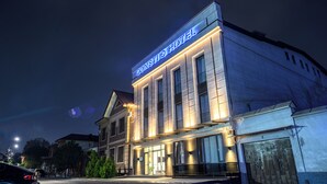 A hotel with a prominent sign, large windows, and a well-lit entrance. - Consti Hotel Tashkent (Tashkent)