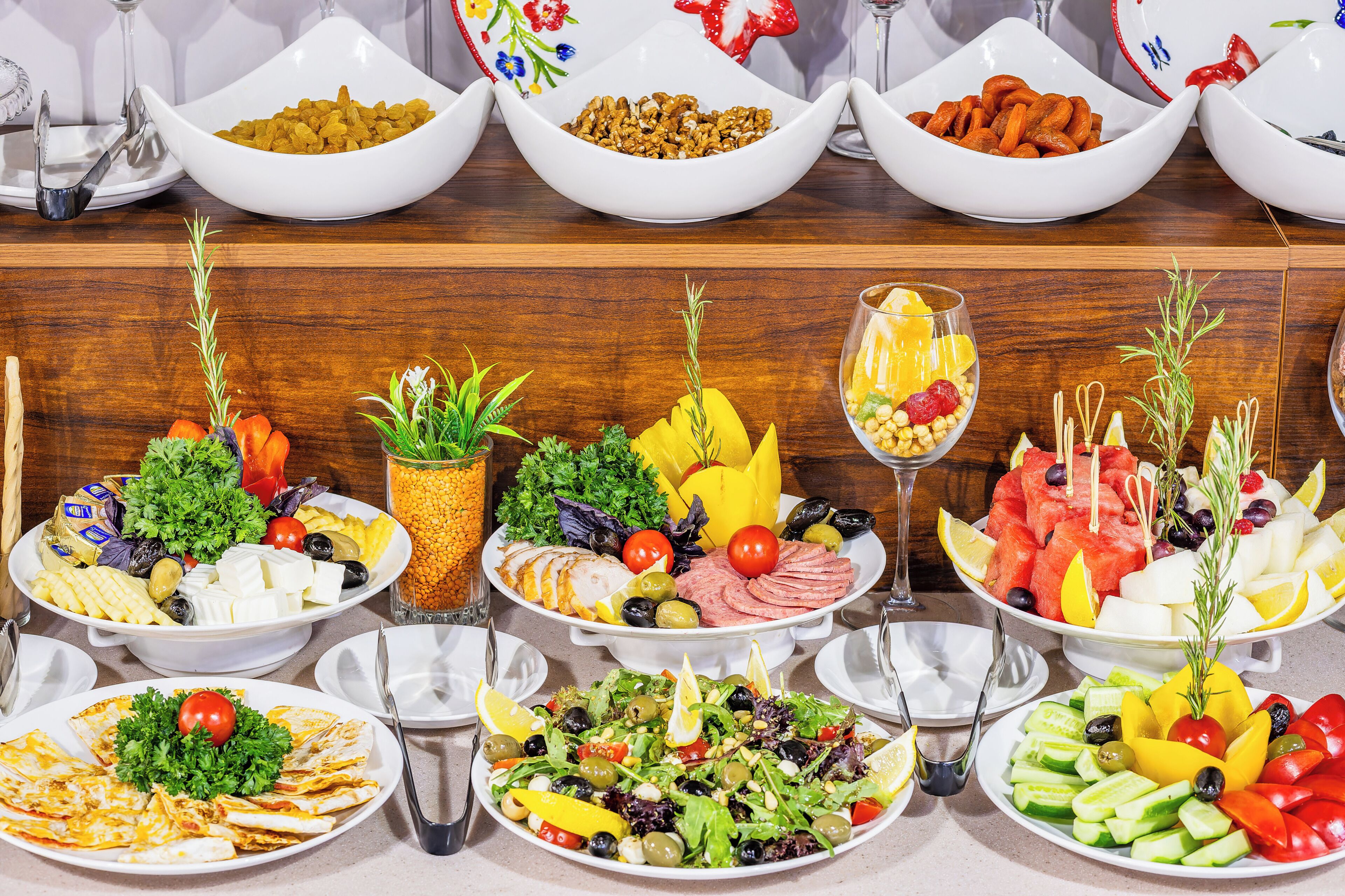 Un tavolo da buffet con diversi cibi e un bicchiere di succo.