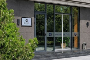 A hotel entrance with a sign reading 'ONSTI HOTEL' and a logo. - Consti Hotel Tashkent (Tashkent)