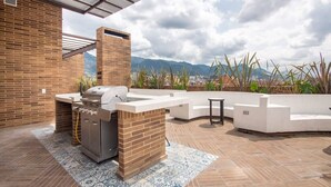 Eine Außenpatio mit Grill, Sitzbereich und Bergblick.