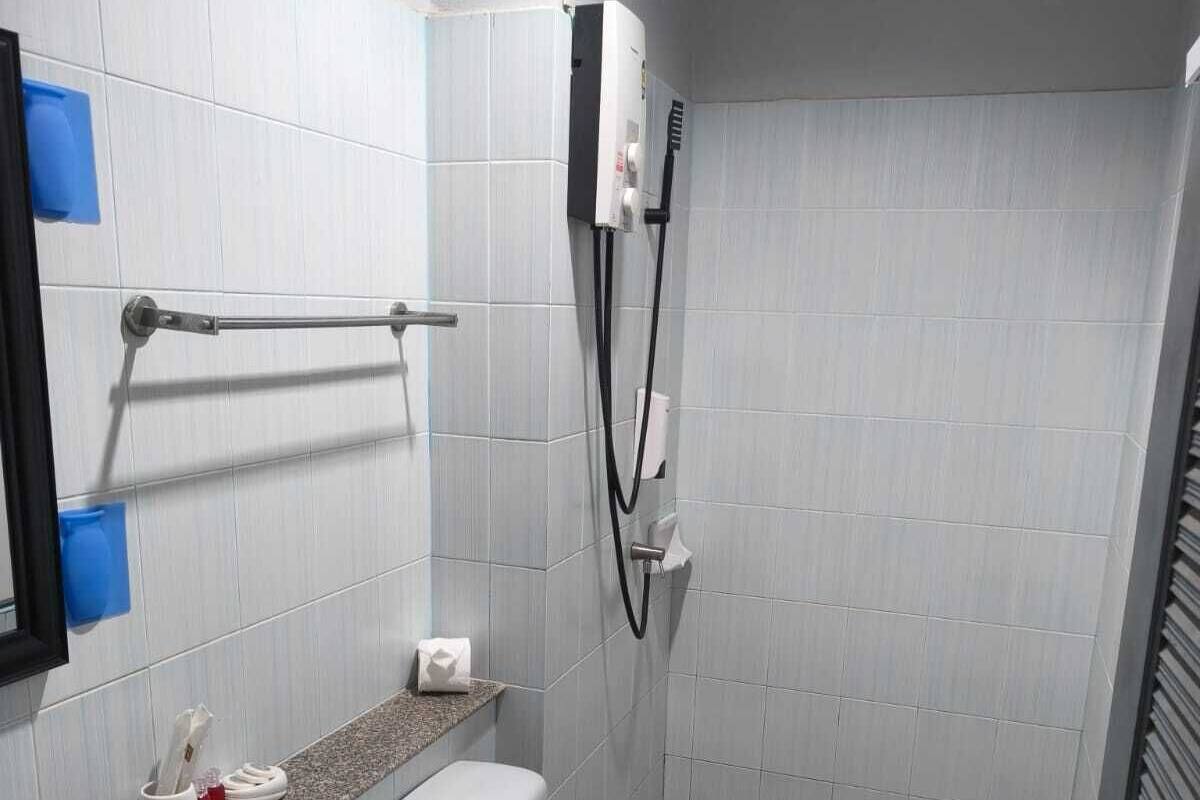 Un baño con lavamanos, inodoro, toallero y cabina de ducha.