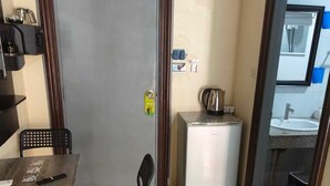A compact living space with a dining area, a kitchenette, and a door leading to a bathroom. - Kata Happy Place (Karon)