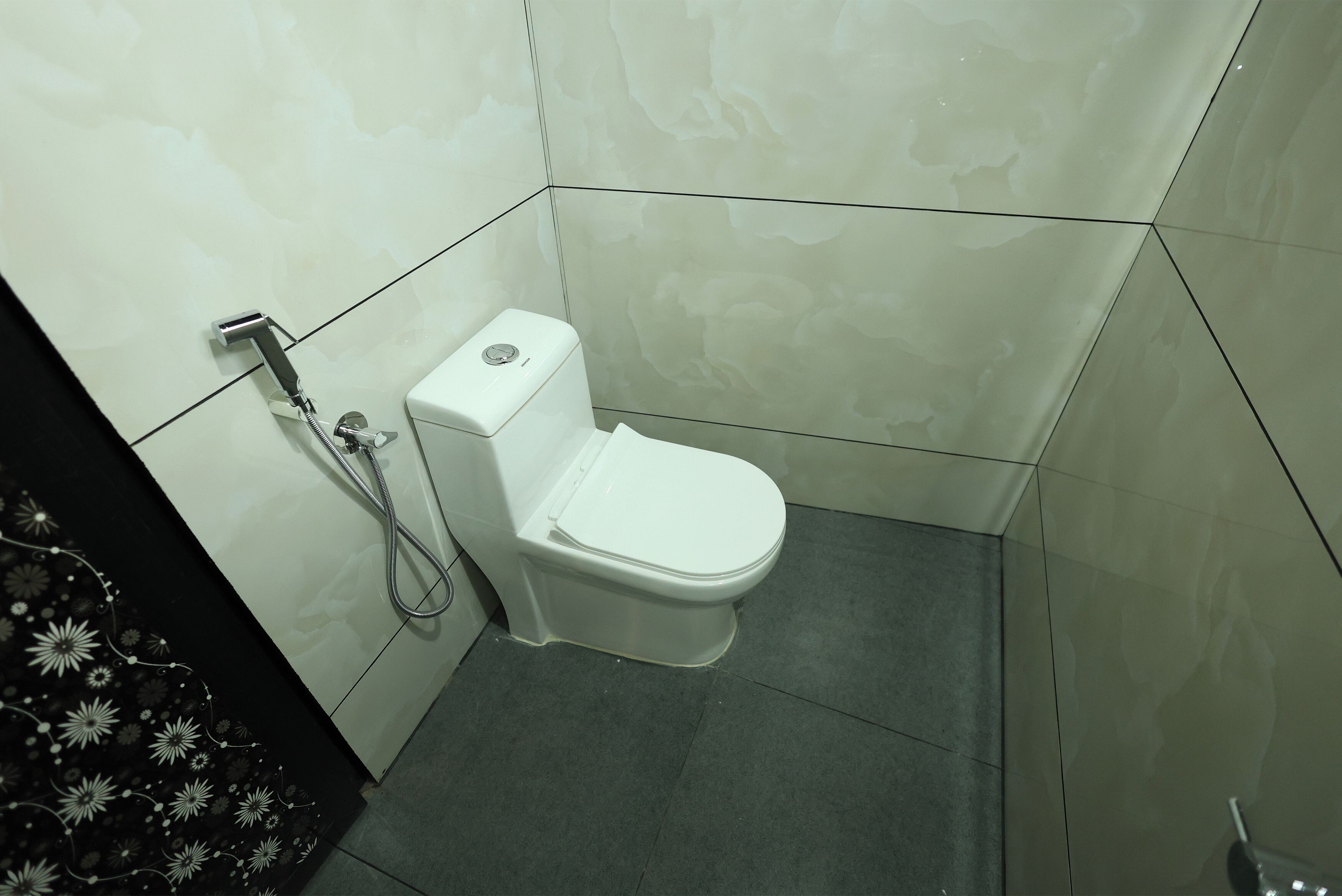 A small, modern bathroom with a white toilet and a shower unit.