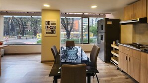 A modern kitchen with a dining area, large windows, and a motivational poster. - Cozy Loft Chpinero in Bogot (Bogotá)
