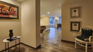 A hotel lobby with a wooden floor, a reception desk, a dining area, and a living room with a sofa and chairs. - Cozy Loft Chpinero in Bogot (Bogotá)