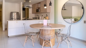 A modern kitchen with a central island, stainless steel appliances, and a round mirror on the wall. - Stylish 3BR in Laureles MDE (Medellín)