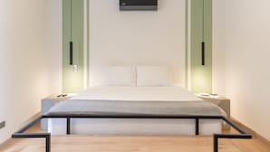 A modern bedroom with a bed, green cabinets, and a ceiling-mounted air conditioner. - Stylish 3BR in Laureles MDE (Medellín)