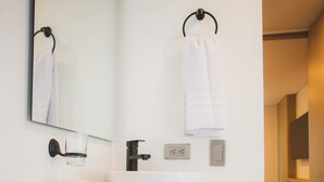 A modern bathroom with a white sink, a mirror, and a towel rack. - Cozy 3 BR in Laureles in Medell n (Medellín)
