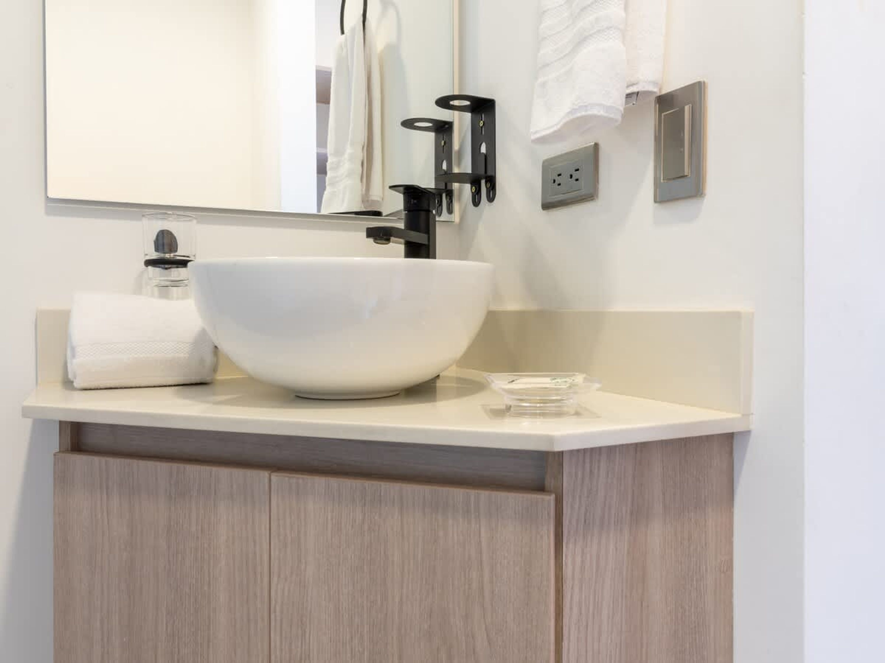 Une salle de bain moderne avec un grand lavabo sur pied blanc, un miroir et un porte-serviettes.