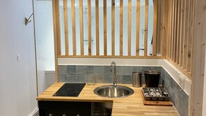 A compact kitchen with a wooden countertop, stainless steel sink, and a built-in oven. - Balnéo Rouen center (Rouen)