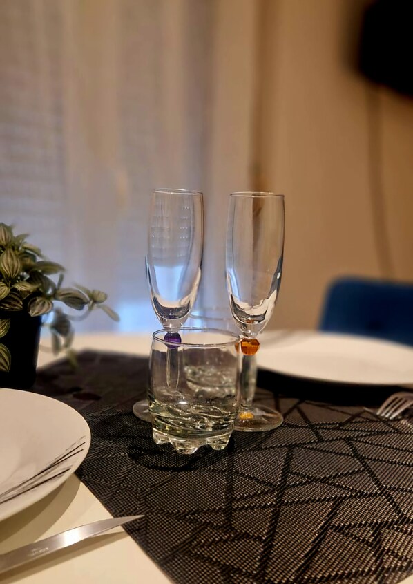 Une table à manger avec deux verres transparents, une assiette blanche et un couteau.