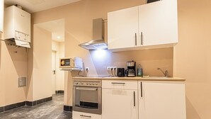 A modern kitchen with white cabinets, a stainless steel stove, and a built-in oven. - 4BR Apt. for Groups 6-Min to Stadthalle (Vienna)