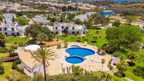 Un complexe hôtelier comprenant plusieurs villas, une piscine centrale et offrant une vue sur le paysage environnant.