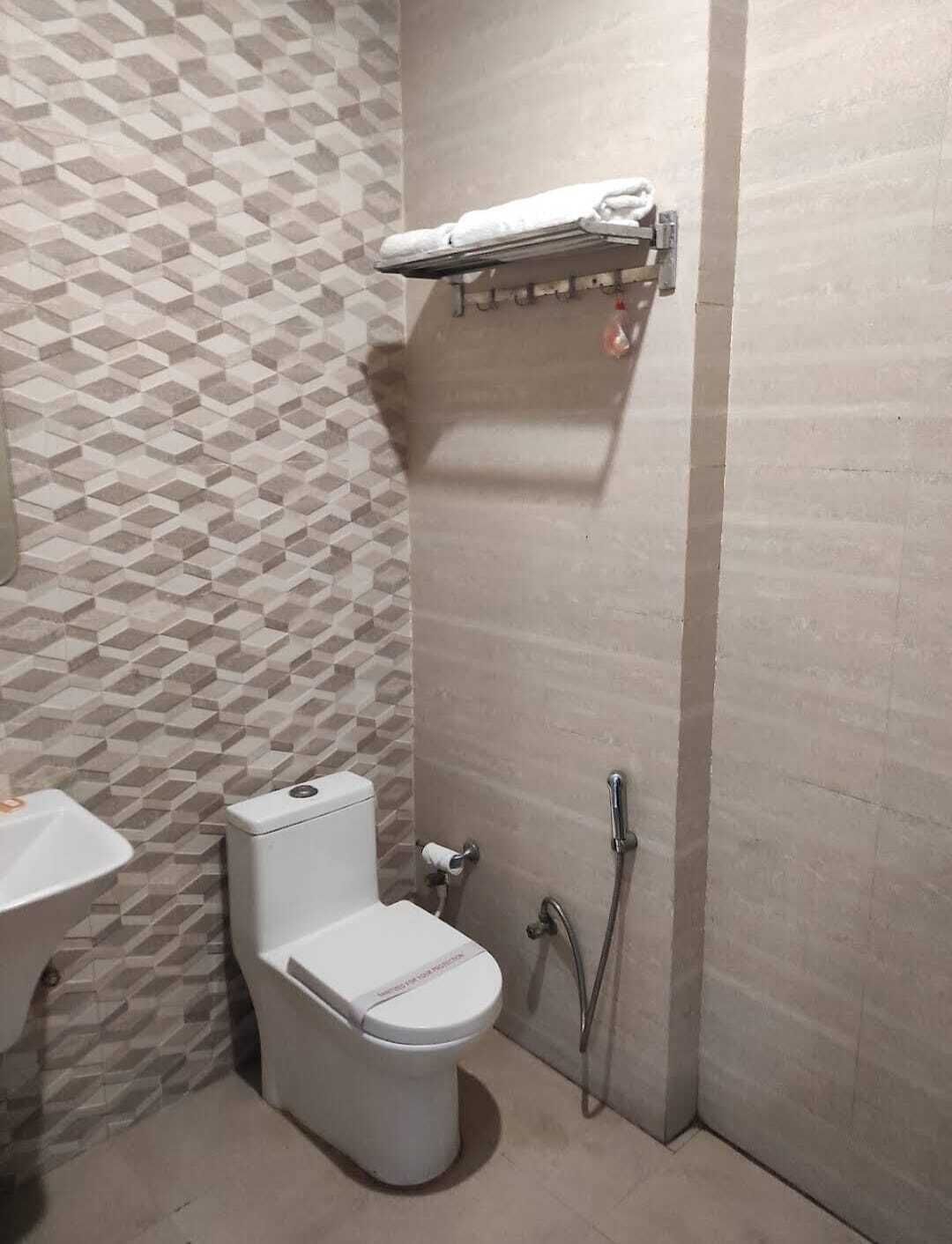 A bathroom with a toilet, a sink, and a shower area.
