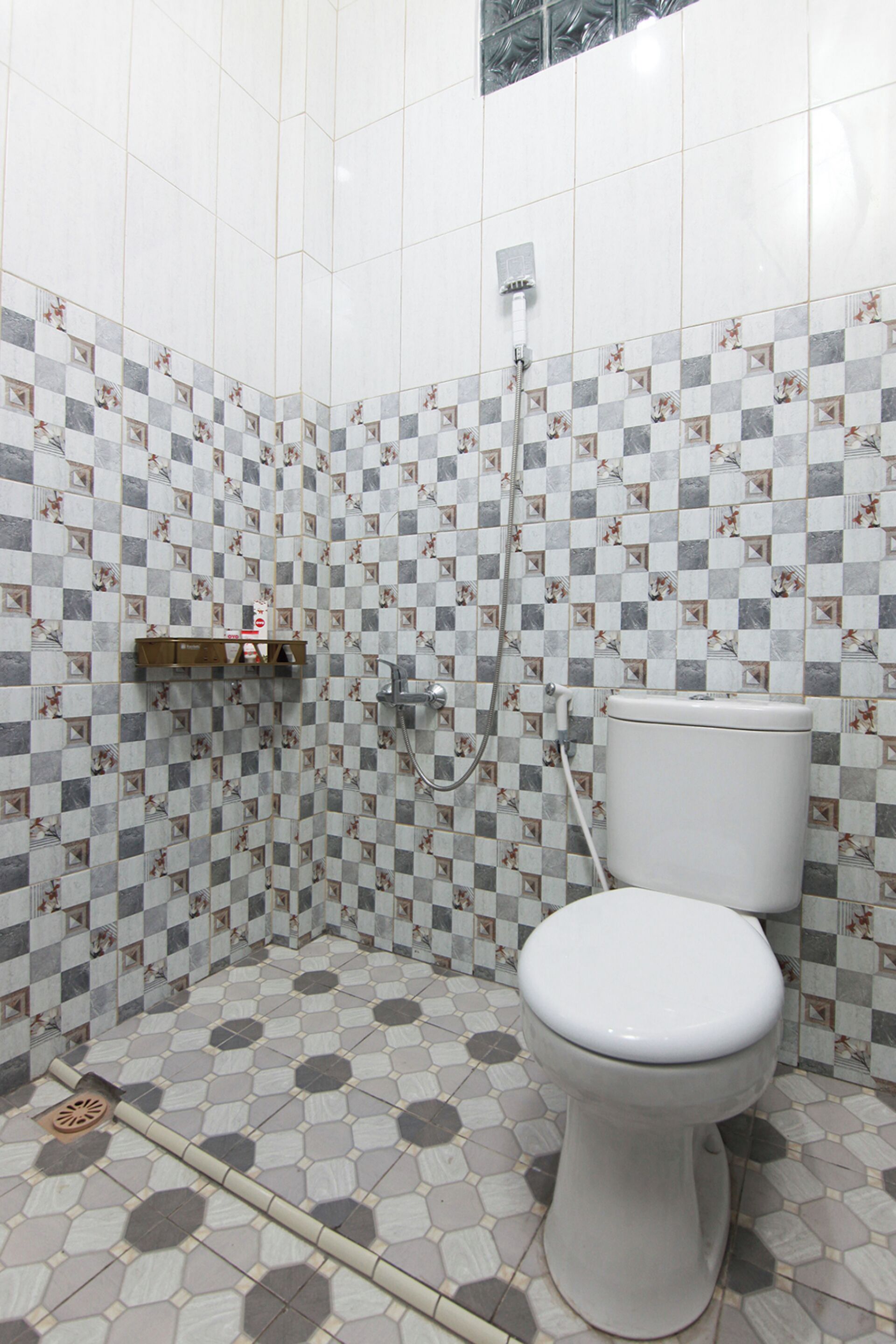 A bathroom with a toilet, shower, and tiled walls.
