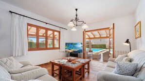Una sala de estar acogedora con una mesa de madera, sofás y una televisión.