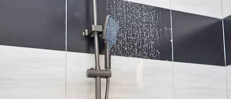 A modern shower with a rain showerhead and handheld control.