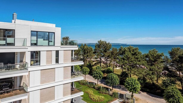 A modern multi-story building with balconies overlooking a coastal area. - Vacation apartment 7 in the Villa Vogue Binz for 4 persons, sea view, on the street (Binz)