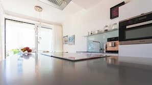 A modern kitchen with a central island, built-in appliances, and a glass backsplash. - Vacation apartment 7 in the Villa Vogue Binz for 4 persons, sea view, on the street (Binz)