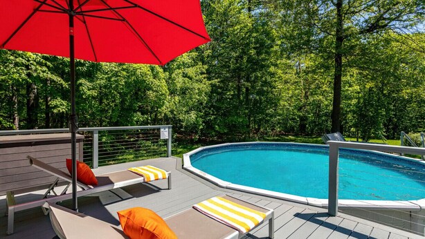 Uma área na piscina com espreguiçadeiras e um guarda-sol.