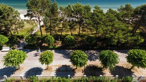 A coastal area with a paved walkway, trees, and a beach in the background. - Vacation apartment Greta`s Beach Home in the Villa Vogue for 4 persons, Meeresbl (Binz)