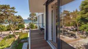 A modern balcony with a view of the sea, wooden flooring, and outdoor furniture. - Vacation apartment Greta`s Beach Home in the Villa Vogue for 4 persons, Meeresbl (Binz)