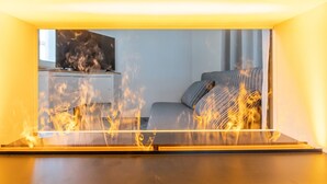 A room with a bed, a TV on a stand, and a window. - Vacation apartment Sabei Villa Metropol, fireplace, sauna, close to the beach, beach chair (Binz)