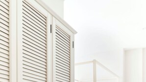 Ein Schlafzimmer mit einem Himmelbett, einem großen Kleiderschrank und einer runden Wanddekoration.
