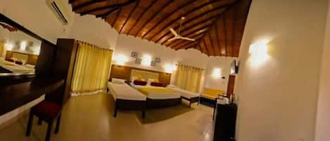 A hotel room with a wooden ceiling, a large bed, a desk, and a chair.