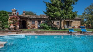 A pool area with a stone building, a large tree, and two lounge chairs. - Grace Home Pool Wifi Gambassi Terme (Gambassi Terme)