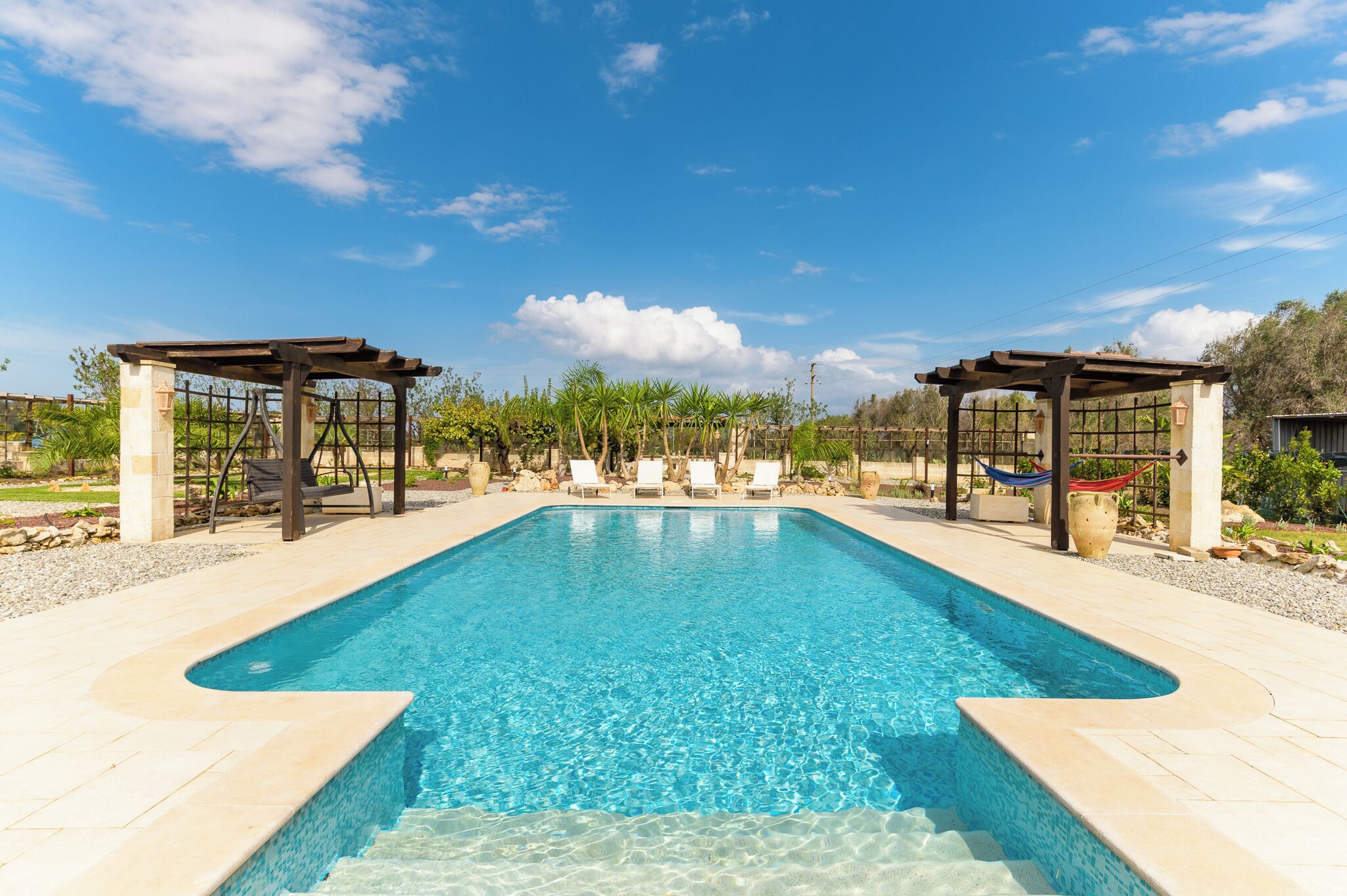 Una piscina al aire libre de temporada, sillones reclinables de piscina