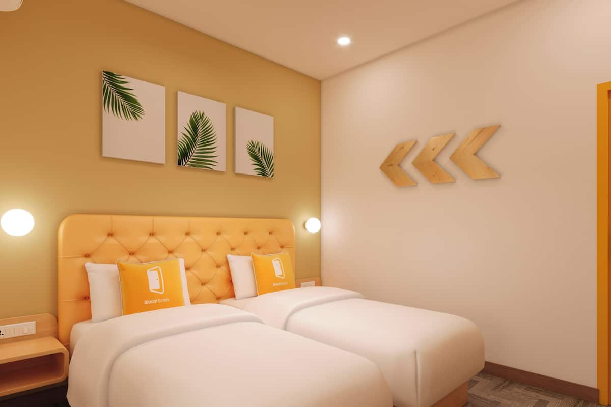A hotel room with a tufted headboard, two beds with white bedding, and three palm leaf wall art pieces.