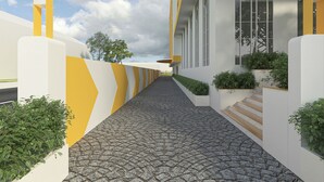 A modern building with a curved facade, a paved pathway, and greenery along the sides. - Bloom Hotel - Taloja Navi Mumbai (Panvel)