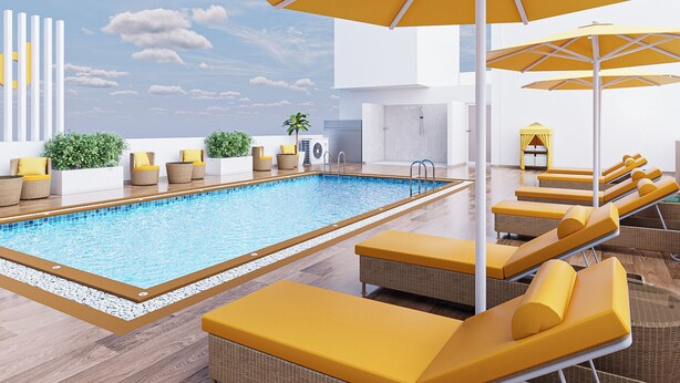 A rooftop pool area with yellow loungers, umbrellas, and a clear view of the sky. - Bloom Hotel - Taloja Navi Mumbai (Panvel)