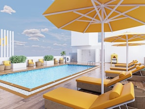 Área de piscina no terraço com espreguiçadeiras amarelas, guarda-sóis e vista ampla do céu.