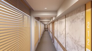 A hallway with wooden slatted blinds, marble walls, and numbered doors. - Bloom Hotel - Taloja Navi Mumbai (Panvel)
