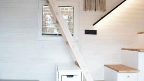 Un escalier avec une rampe en bois menant à une mezzanine.