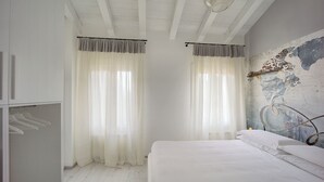 Ein Schlafzimmer mit Bett, Kleiderschrank und einer Wand mit abblätternder Farbe.