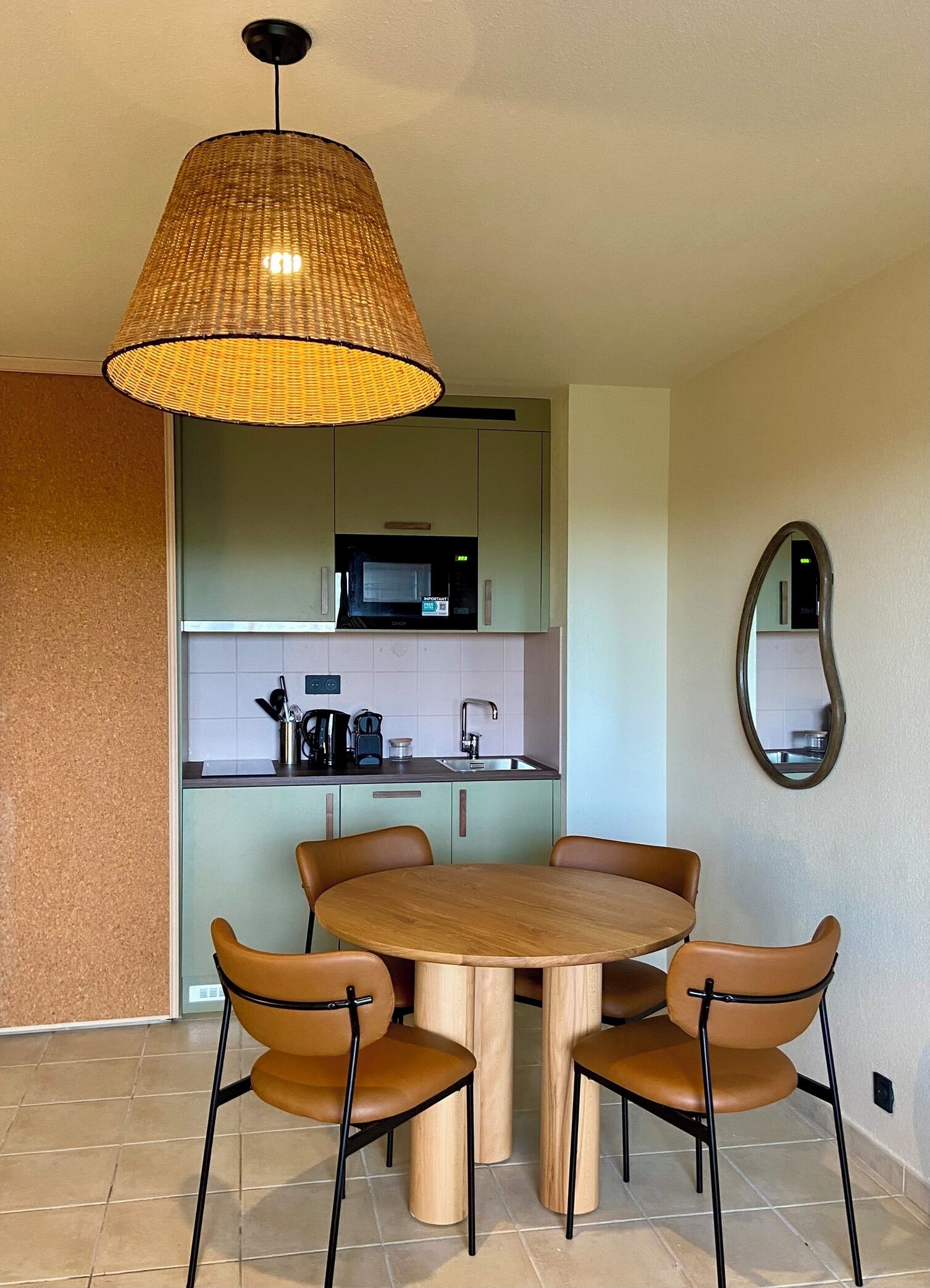 A modern kitchen with a microwave, sink, and a round dining table with four chairs.