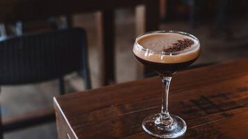 A cocktail in a martini glass on a wooden table.