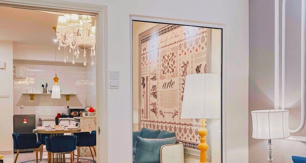 A modern interior with a dining area, a chandelier, and a decorative wall panel. - Arte Mont Kiara Luxury Suite by Stay Hub (Kuala Lumpur)