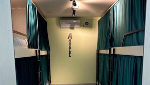 A corridor with bunk beds, a ceiling fan, and an air conditioning unit.