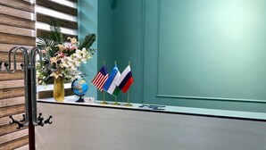 A reception desk with flags, a globe, and a vase of flowers.