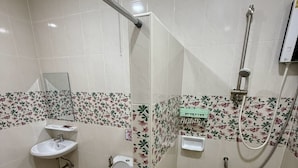 A bathroom with a toilet, sink, and shower. - The Burapa Rooms (Bangkok)