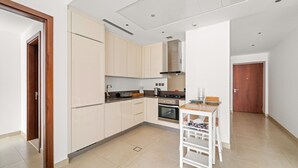 Una cucina moderna con mobili chiari, un'isola centrale con lavello e piano cottura.