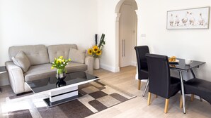 Un salon moderne avec un canapé, une table basse et un coin repas.