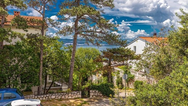 Ein Küstenanwesen mit einer Steinmauer, einem weißen Gebäude und Blick auf das Meer.