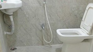 Un baño con inodoro, lavamanos y ducha.